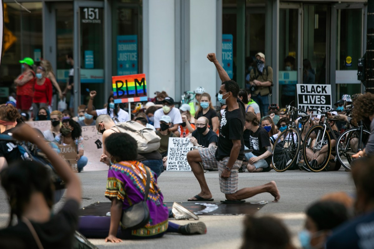 Protesters sit and kneel in silence for nearly nine minutes in Chicago on Saturday, July 4, 2020, during the "Boycott 4th of July" rally against police brutality.